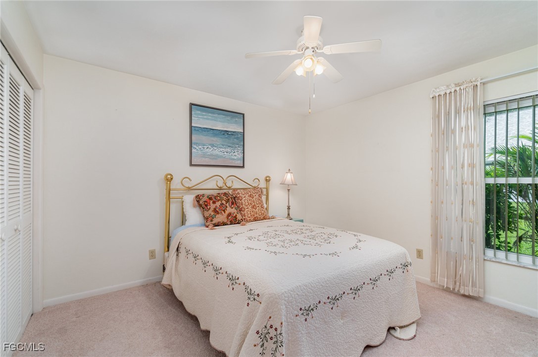 10615 Roxbury Court Lehigh Acres, FL 33936 - Photo 18 of 33 a bedroom with a bed and a chandelier