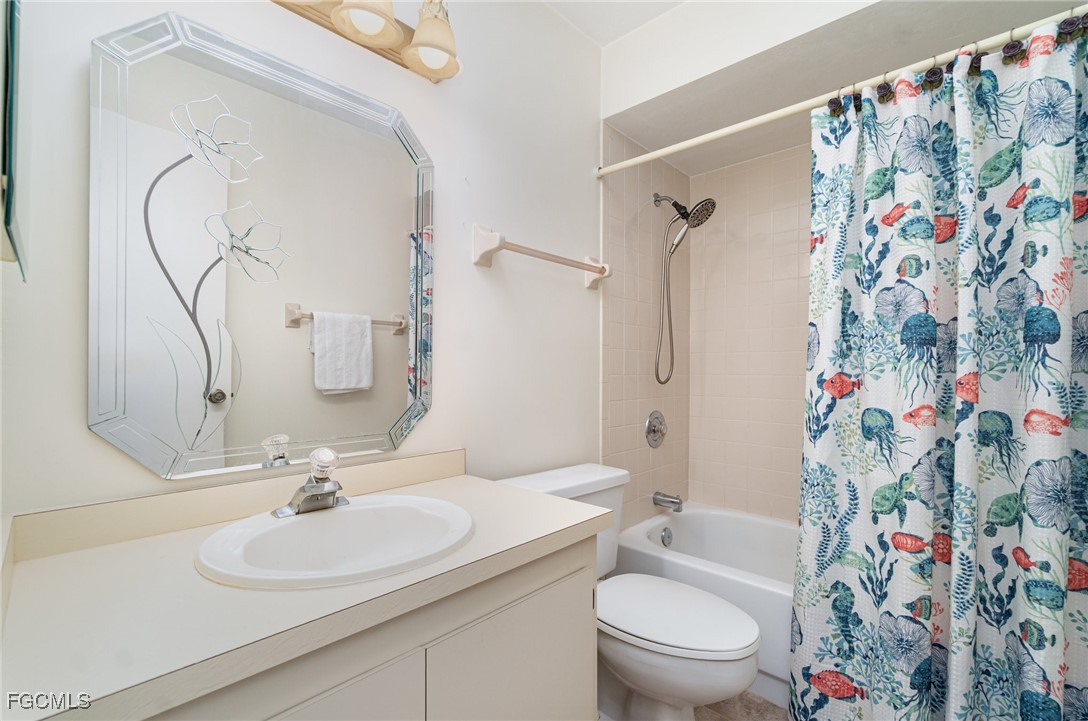 10615 Roxbury Court Lehigh Acres, FL 33936 - Photo 20 of 33 a bathroom with a sink toilet and shower curtain