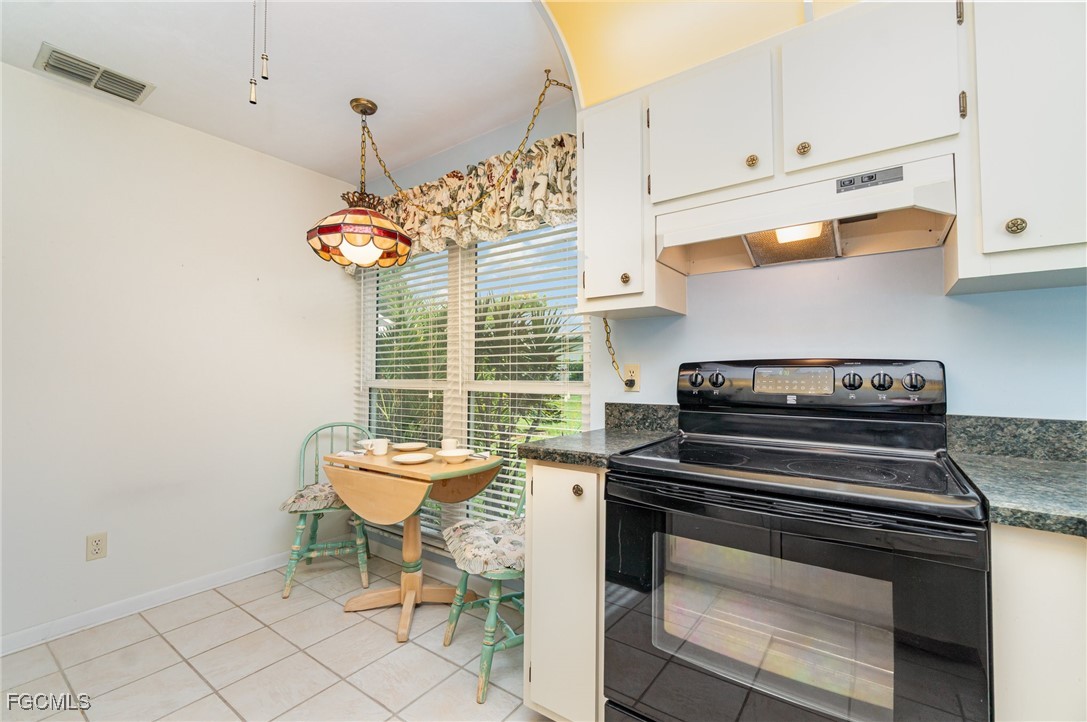 10615 Roxbury Court Lehigh Acres, FL 33936 - Photo 10 of 33 a kitchen with a stove and a cabinet