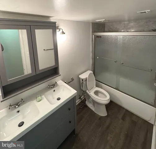 a bathroom with a toilet a sink and mirror
