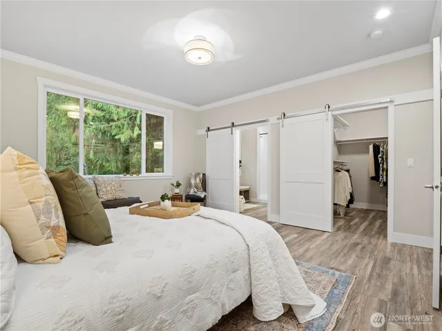 a bedroom with a bed and a large window