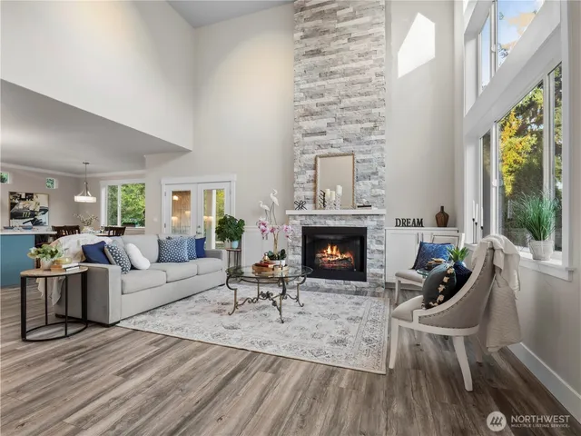 a living room with furniture a fireplace and a floor to ceiling window