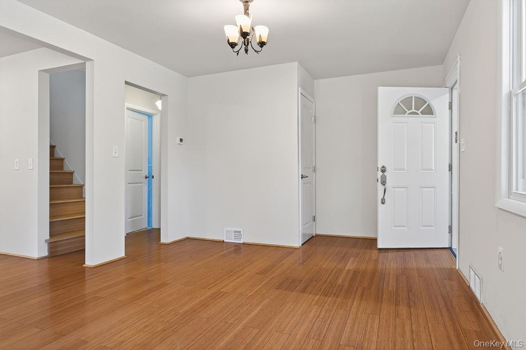 6 Winterberry Road Fishkill, NY 12524 - Photo 6 of 43 Entry area featuring wood-finish flooring, a white paneled entry door with an arched transom, and a coat closet.