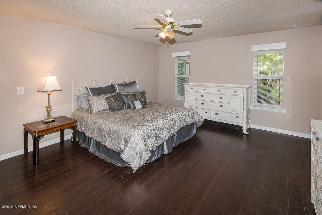 11012 Reading Road Jacksonville, FL 32257 - Photo 18 of 29 a bedroom with a bed chandelier and a window