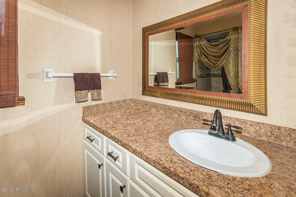 11012 Reading Road Jacksonville, FL 32257 - Photo 19 of 29 a bathroom with a granite countertop sink and a mirror
