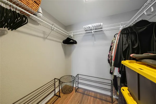 a view of walk in closet with clothes and shoes