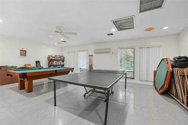 a room with furniture pool table and windows
