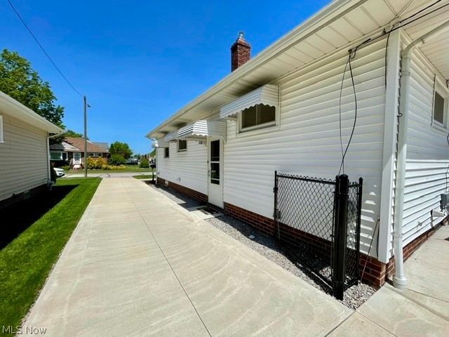 28634 Forest Road Willowick, OH 44095 - Photo 5 of 39 Concrete driveway spanning the length of the property, bordered by a manicured lawn and white vinyl siding