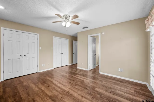 a bathroom with a granite countertop sink a toilet and a mirror