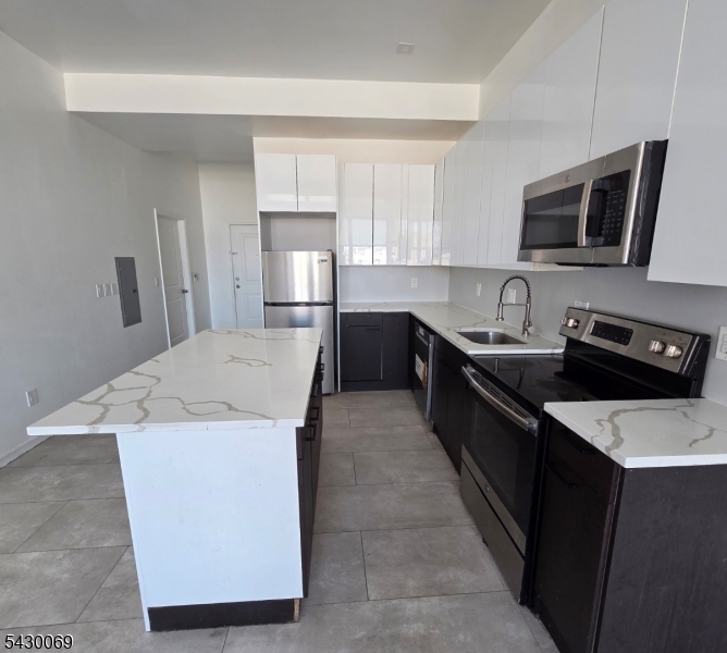 30 Howe Avenue, Unit 303 Passaic, NJ 07055 - Photo 2 of 11 a kitchen with a sink a stove top oven and refrigerator