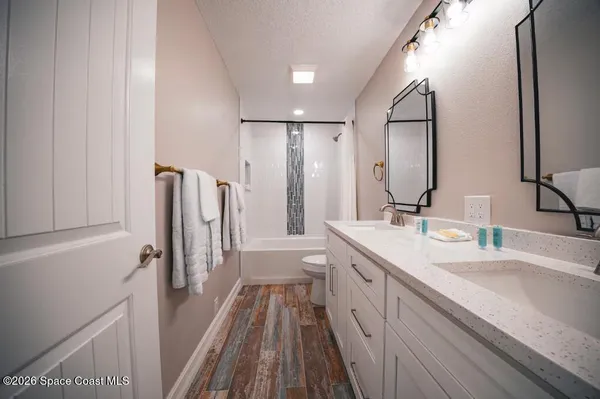 a spacious bathroom with a double vanity sink a mirror and a shower