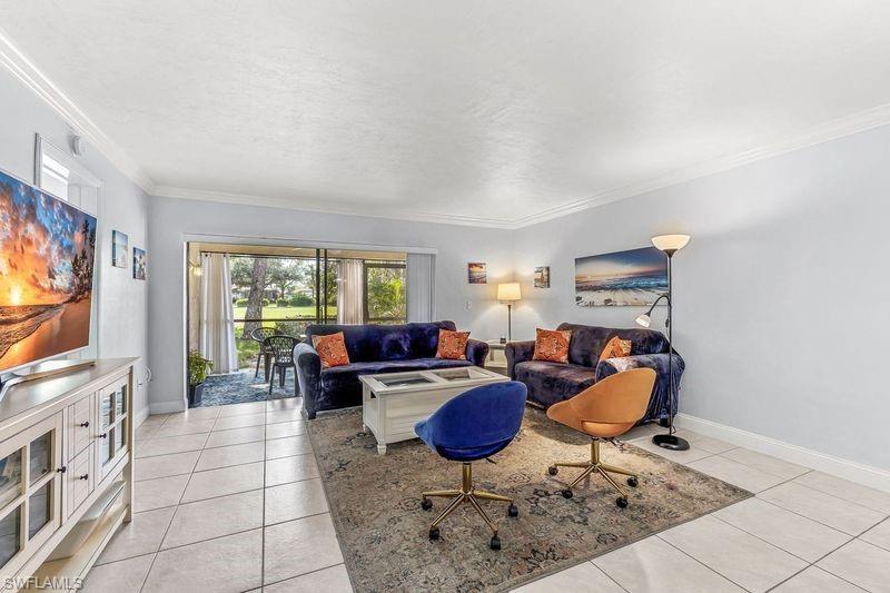 5841 Rattlesnake Hamm Road, Unit I101 Naples, FL 34113 - Photo 6 of 17 Tiled living room featuring crown molding and view of the golf course