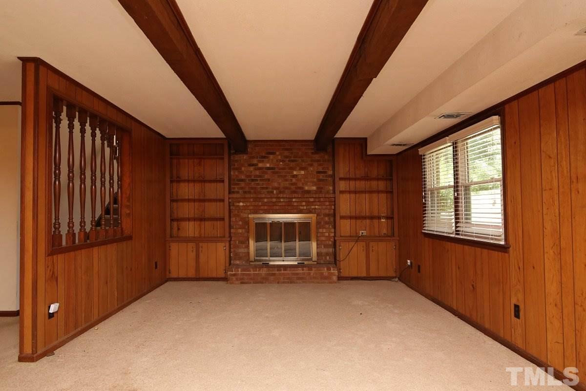 4508 Oak Park Road Raleigh, NC 27612 - Photo 12 of 24 a view of an empty room with a fireplace and windows