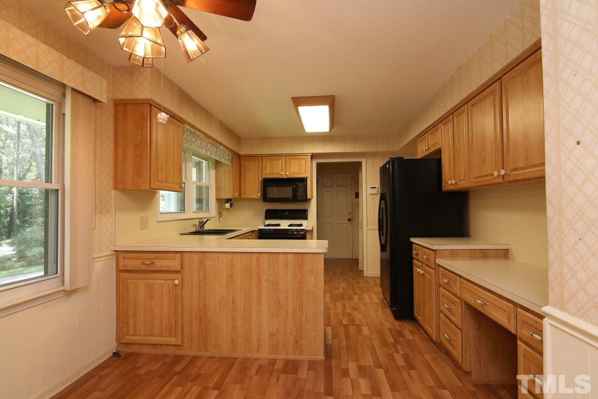 4508 Oak Park Road Raleigh, NC 27612 - Photo 4 of 24 a kitchen with stainless steel appliances a sink cabinets and wooden floor