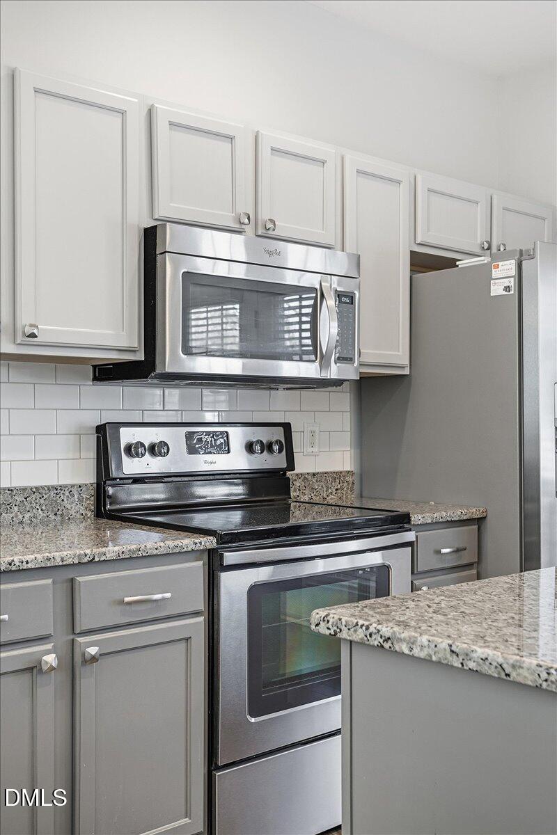 5531 Crabtree Park Court Raleigh, NC 27612 - Photo 8 of 41 a kitchen with stainless steel appliances granite countertop a stove a microwave and a sink