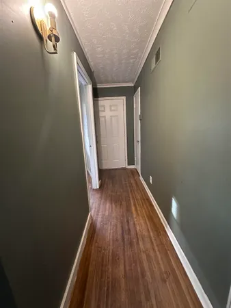 a view of a hallway with wooden floor and staircase