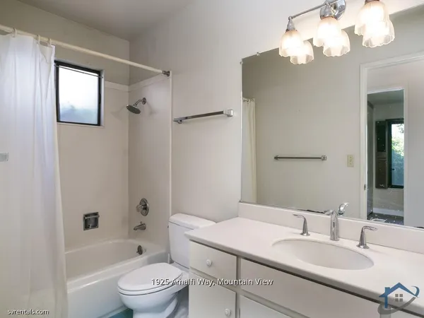a bathroom with a granite countertop sink a toilet and a bathtub