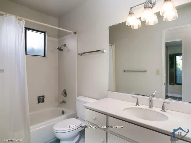 a bathroom with a granite countertop sink a toilet and a bathtub