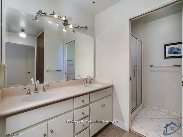 a bathroom with a double vanity sink and a mirror