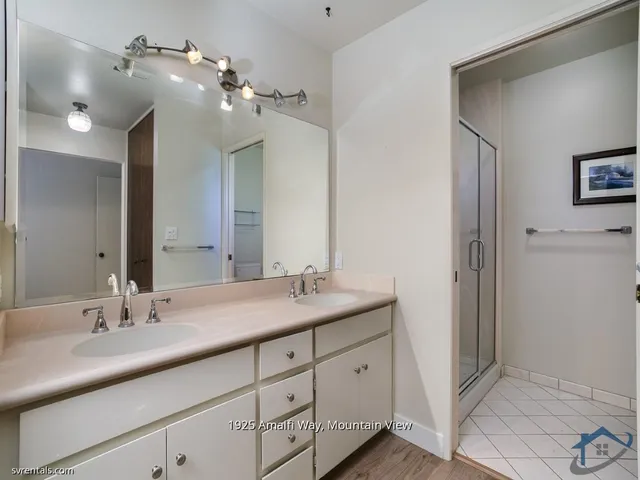 a bathroom with a double vanity sink and a mirror