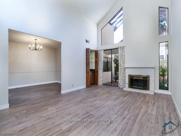 a view of a livingroom with wooden floor a fireplace and window