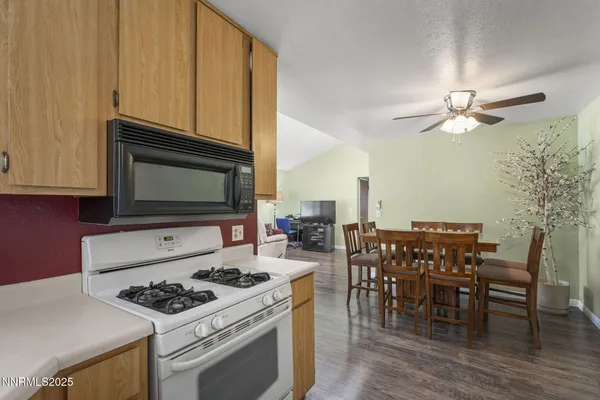 a kitchen with a stove a microwave and wooden floor