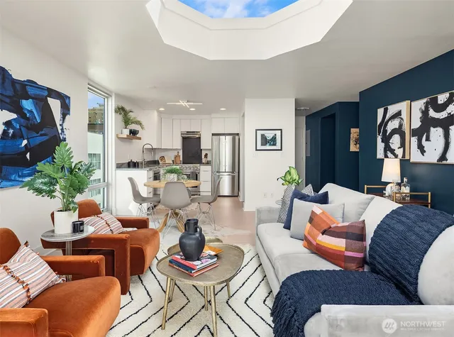 a living room with furniture kitchen view and a potted plant