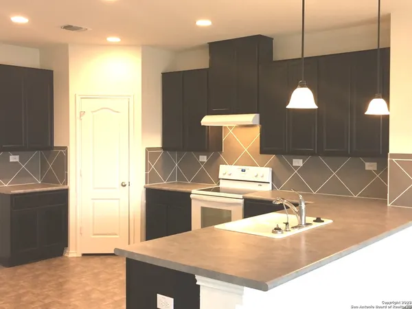 a kitchen with kitchen island sink and refrigerator