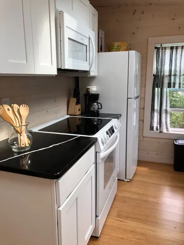a kitchen with stainless steel appliances a refrigerator sink and white cabinets