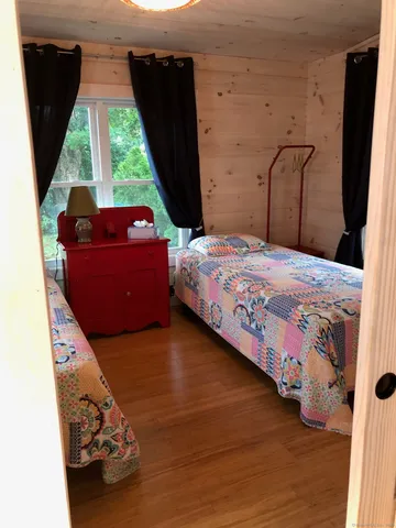 a bedroom with a bed and wooden floor