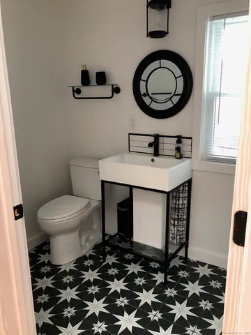 a bathroom with a toilet a sink and a mirror