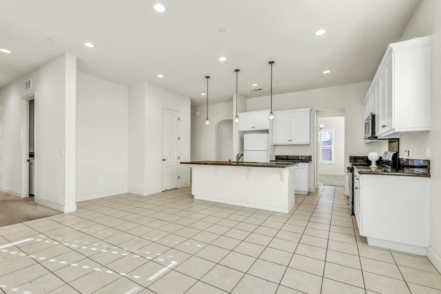 4129 Castellina Way Manteca, CA 95337 - Photo 23 of 58 a large kitchen with granite countertop a large counter top a sink appliances and cabinets