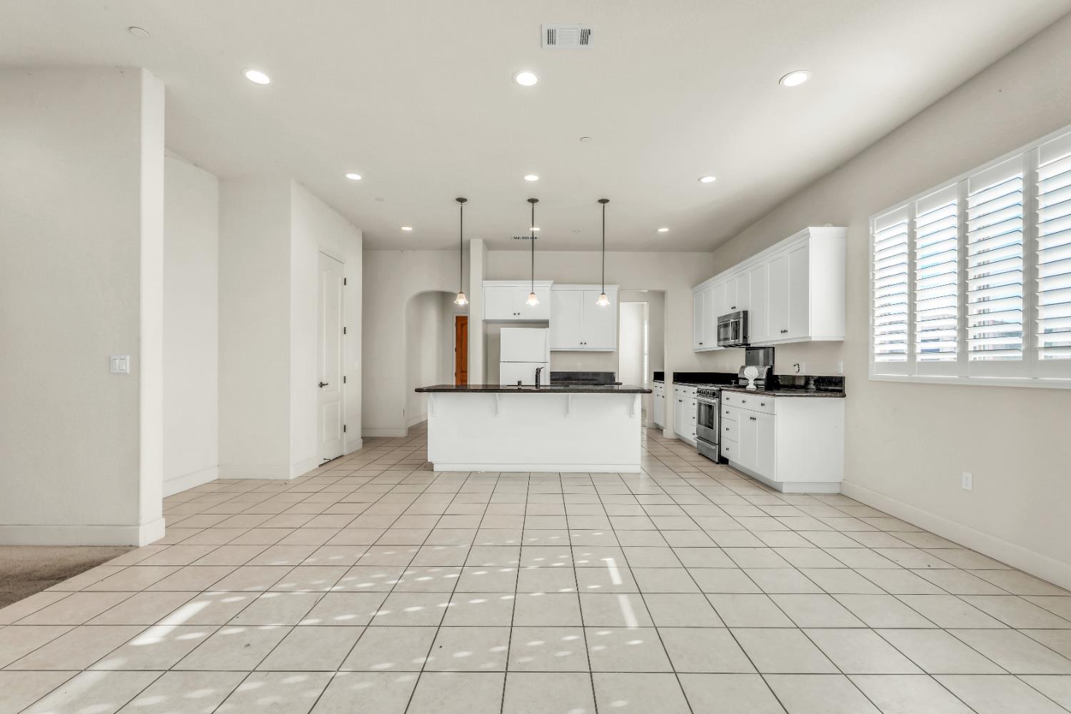4129 Castellina Way Manteca, CA 95337 - Photo 24 of 58 a view of kitchen with kitchen island granite countertop a stove a sink a refrigerator and cabinets