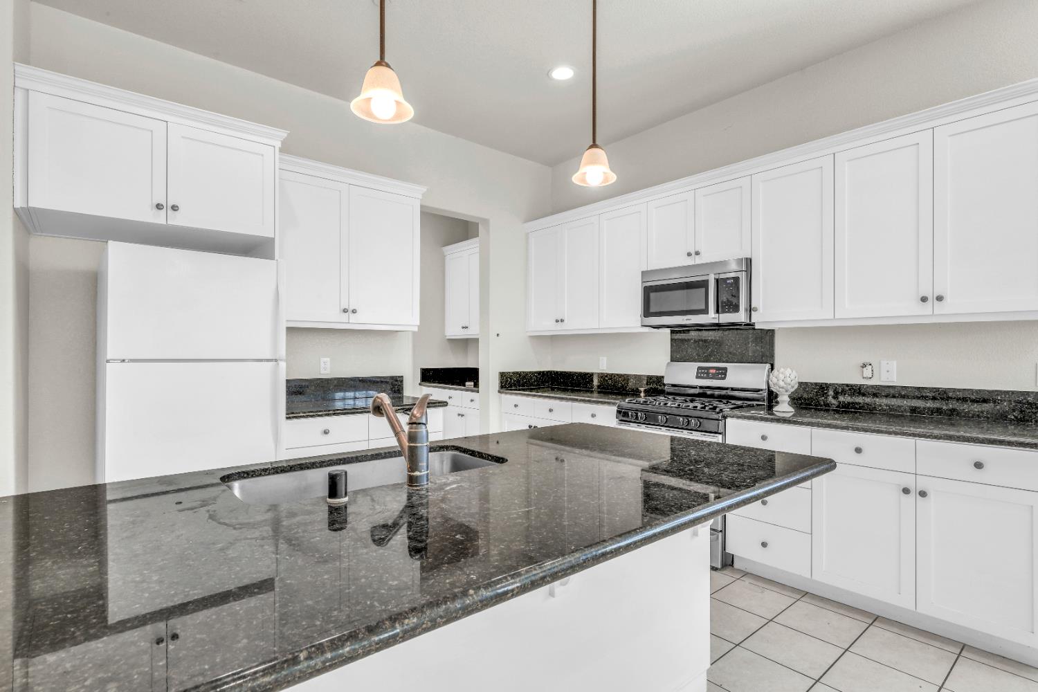 4129 Castellina Way Manteca, CA 95337 - Photo 26 of 58 a kitchen with stainless steel appliances granite countertop a sink a stove and a refrigerator