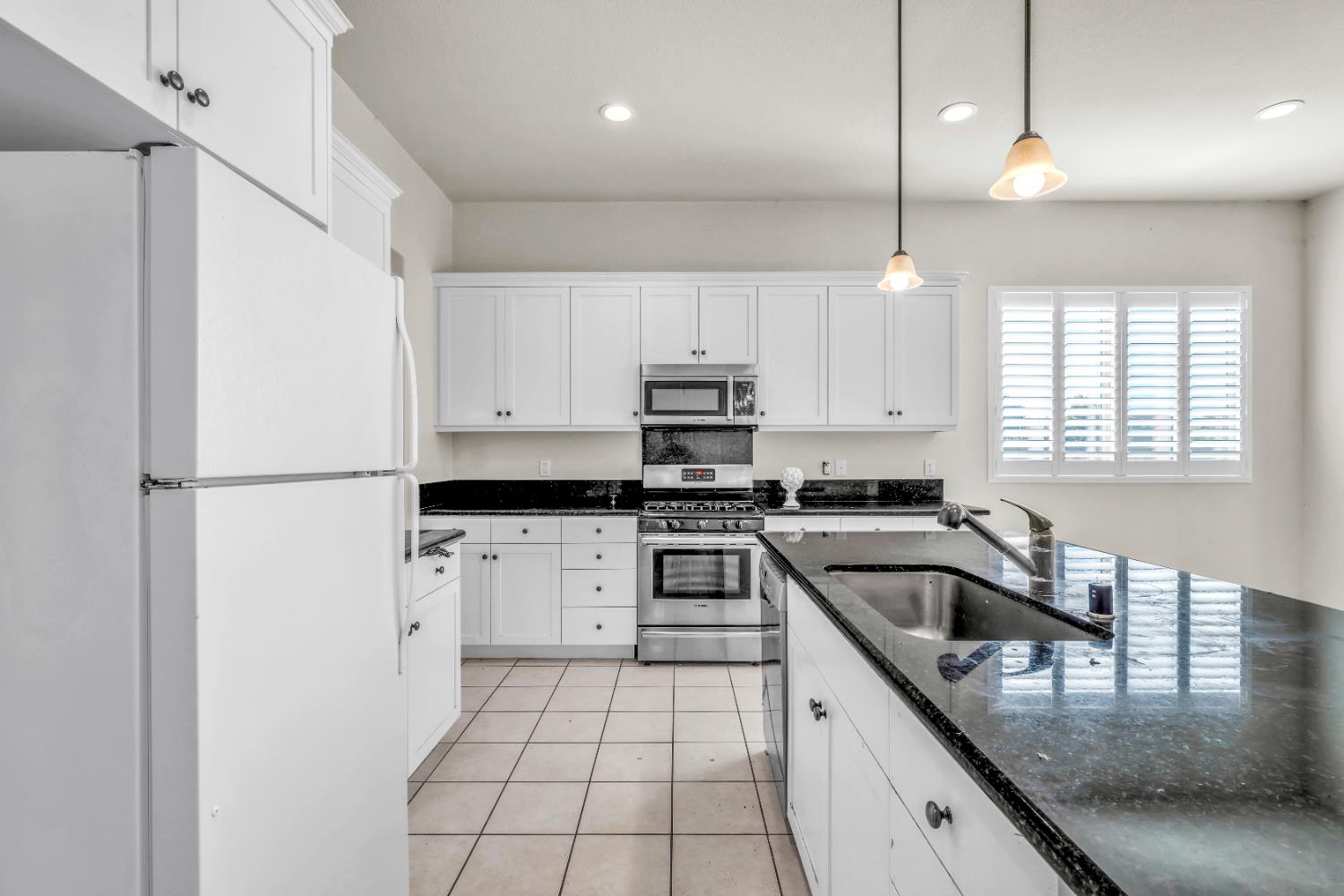 4129 Castellina Way Manteca, CA 95337 - Photo 27 of 58 a kitchen with granite countertop a sink a counter top space stainless steel appliances and cabinets
