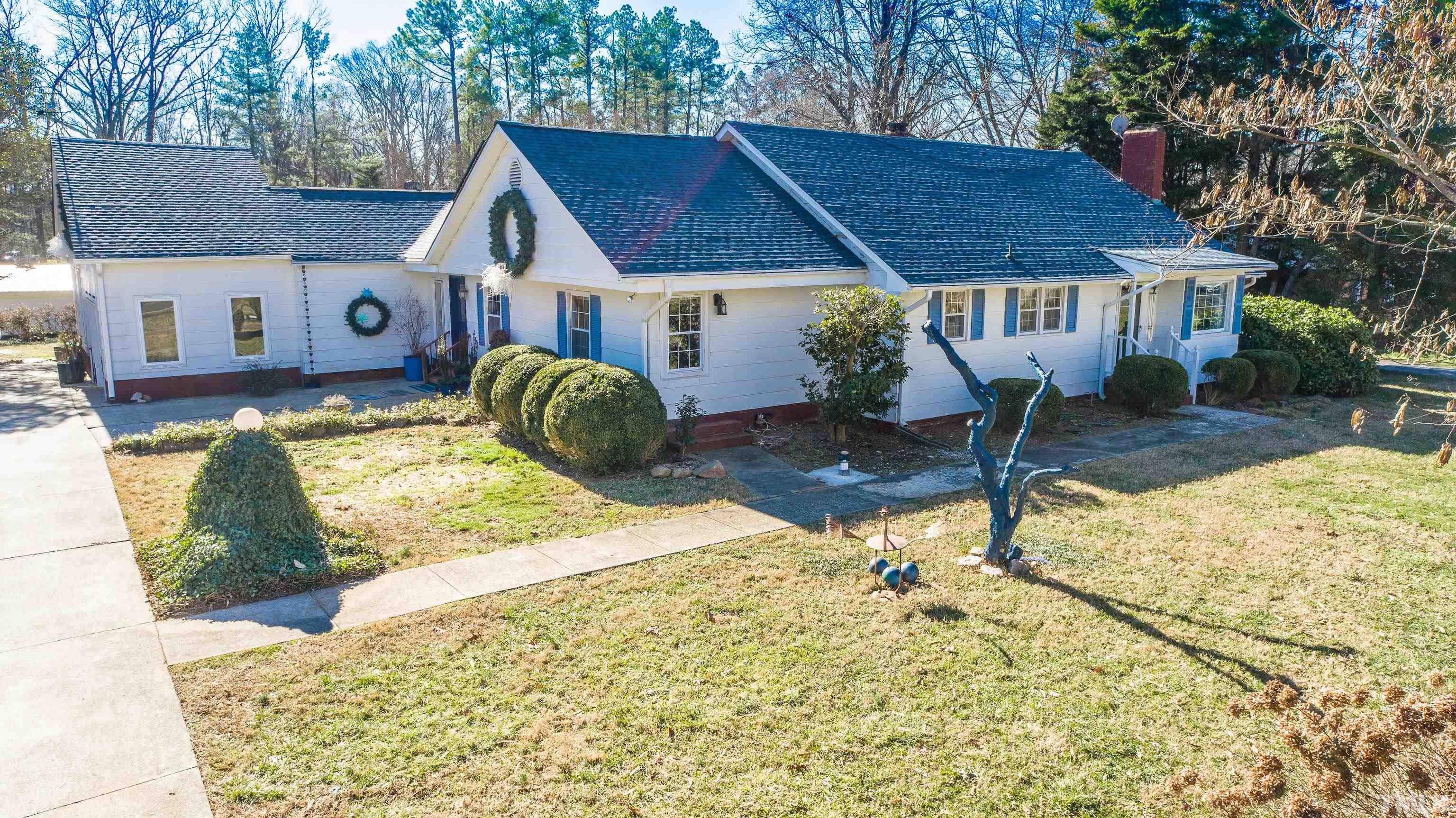 155 Hesters Store Road Roxboro, NC 27574 - Photo 1 of 77 a front view of house with yard outdoor seating and covered with green space
