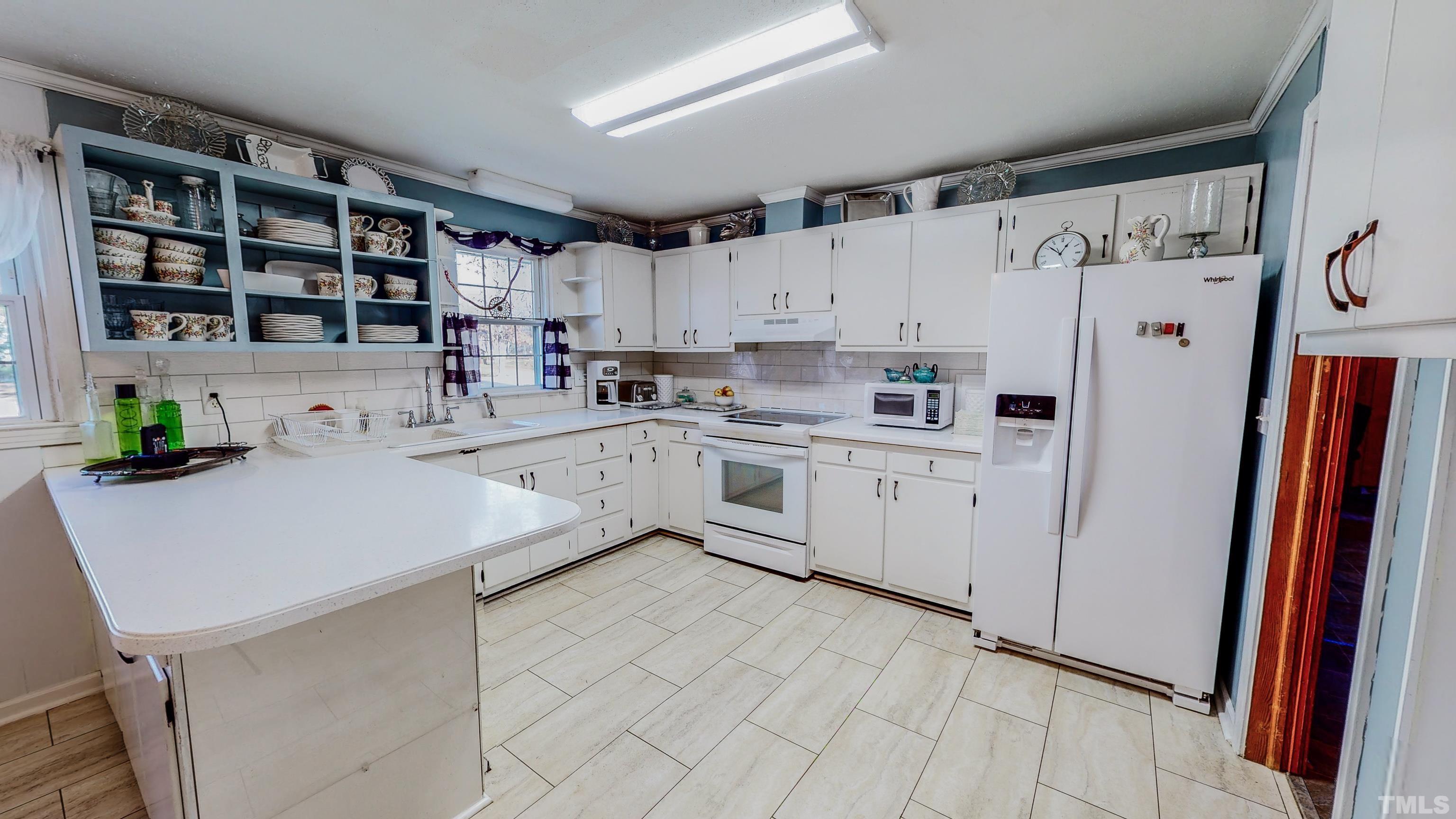 155 Hesters Store Road Roxboro, NC 27574 - Photo 6 of 77 a kitchen with a sink a refrigerator a window and cabinets
