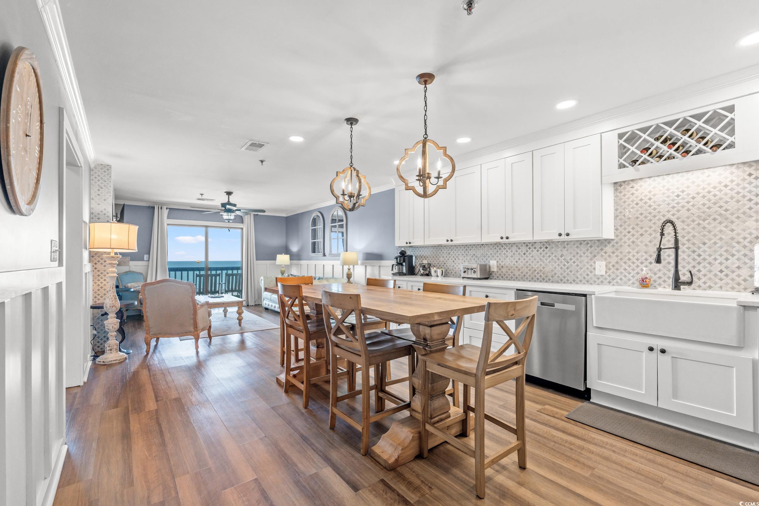 917 Ocean Boulevard South, Unit 304 Surfside Beach, SC 29575 - Photo 11 of 38 Kitchen with a chandelier, white cabinets, wainscoting, stainless steel dishwasher, and light wood-style floors
