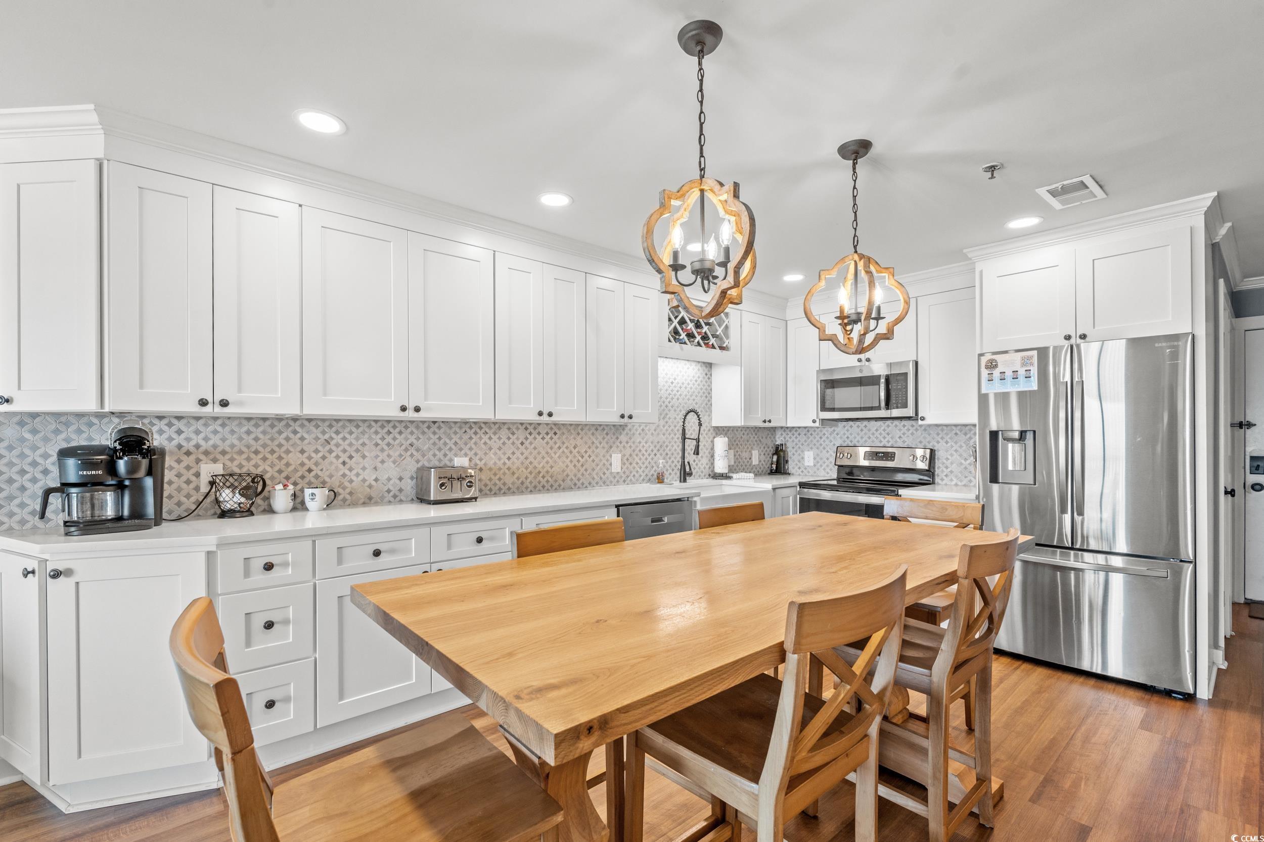 917 Ocean Boulevard South, Unit 304 Surfside Beach, SC 29575 - Photo 12 of 38 Kitchen featuring appliances with stainless steel finishes, white cabinetry, light wood-style floors, decorative backsplash, and recessed lighting