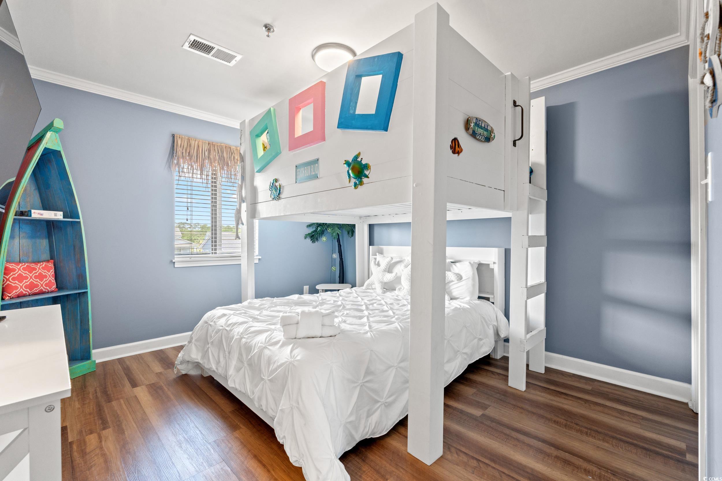 917 Ocean Boulevard South, Unit 304 Surfside Beach, SC 29575 - Photo 19 of 38 Bedroom with crown molding and dark wood-style flooring