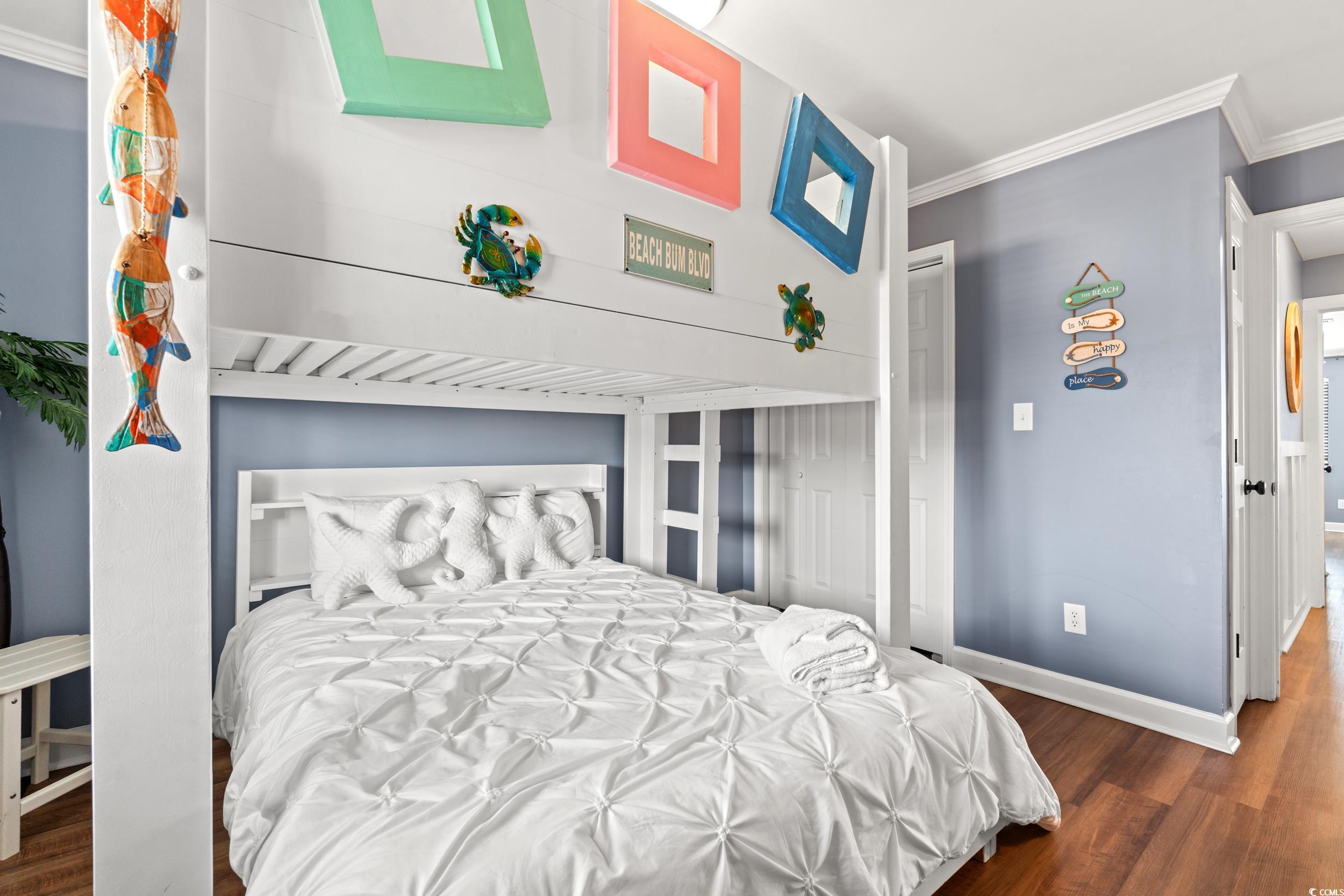 917 Ocean Boulevard South, Unit 304 Surfside Beach, SC 29575 - Photo 20 of 38 Bedroom with crown molding, dark wood-type flooring, and a closet