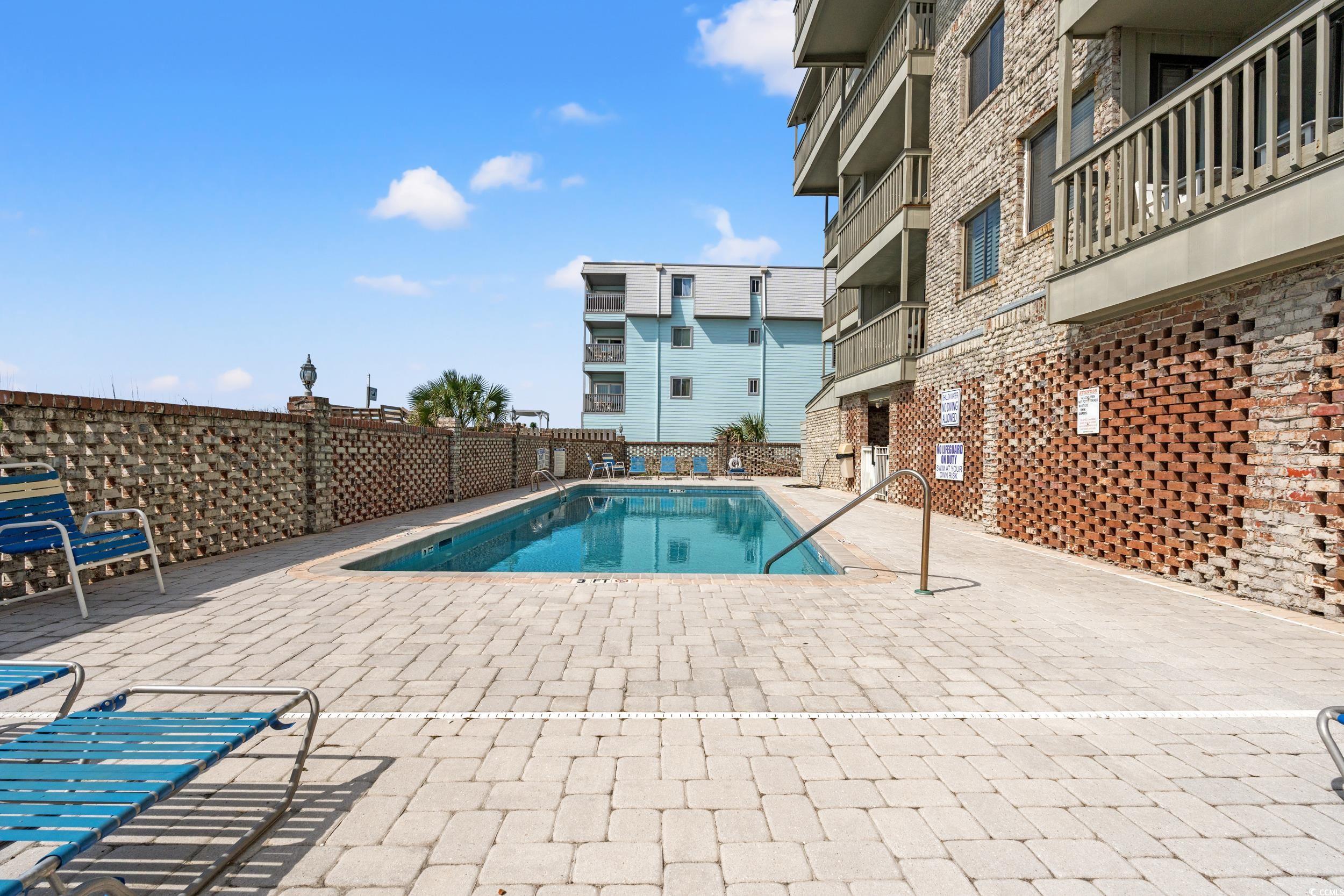 917 Ocean Boulevard South, Unit 304 Surfside Beach, SC 29575 - Photo 23 of 38 Community pool with a balcony and a patio area