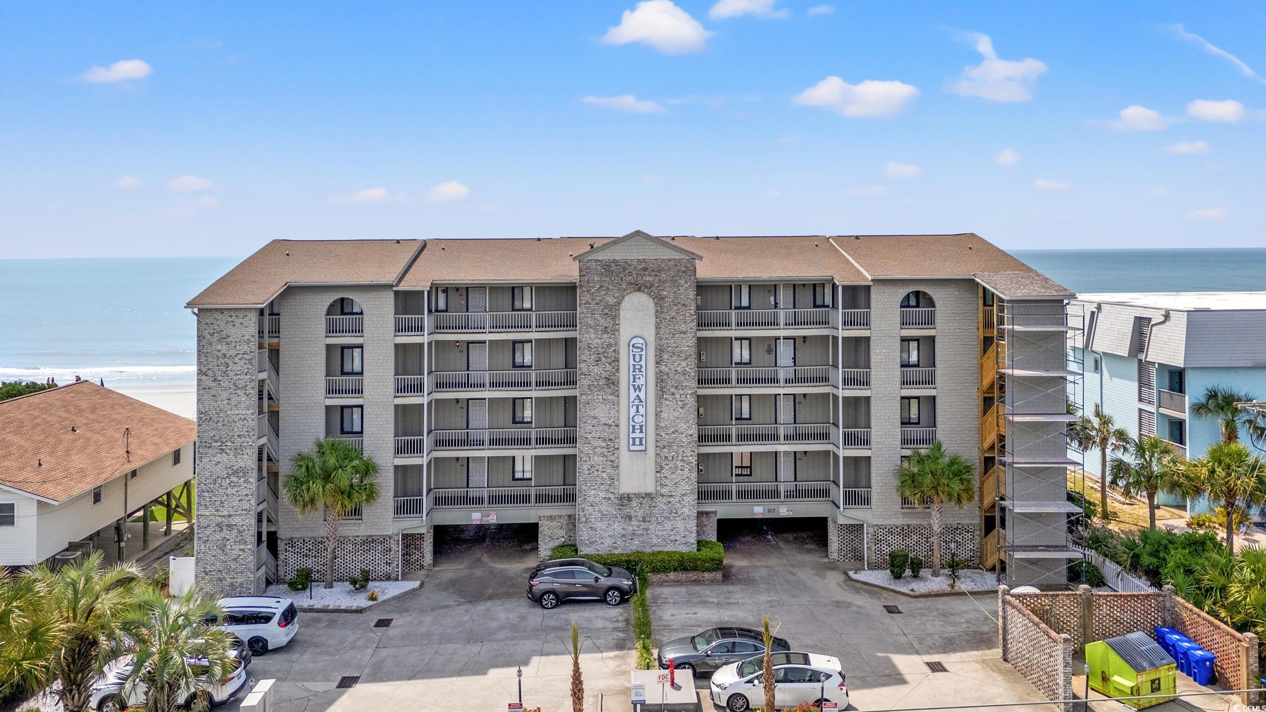 917 Ocean Boulevard South, Unit 304 Surfside Beach, SC 29575 - Photo 36 of 38 View of apartment building / complex with view of water and beach and uncovered parking