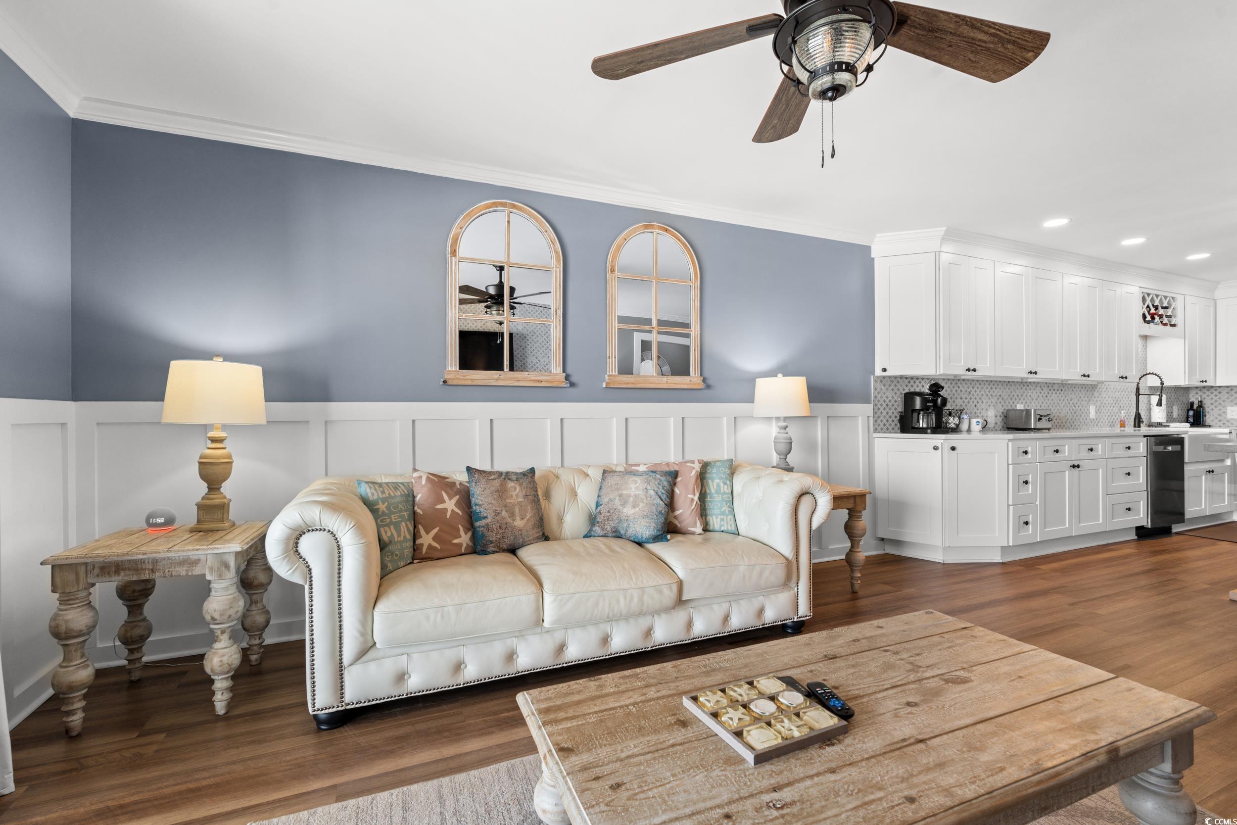 917 Ocean Boulevard South, Unit 304 Surfside Beach, SC 29575 - Photo 4 of 38 Living room with a ceiling fan, ornamental molding, wainscoting, dark wood-type flooring, and a decorative wall