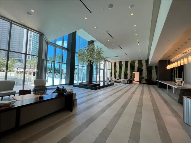 a living room with a table and a potted plant