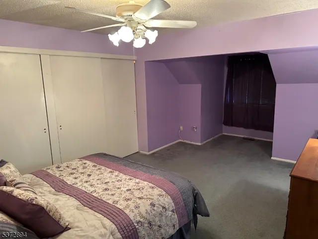 a bedroom with a bed and a chandelier fan