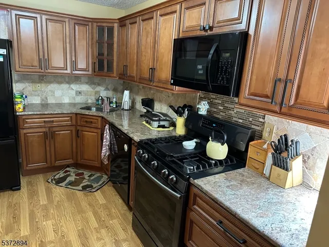 a kitchen with stainless steel appliances granite countertop a stove a sink and a microwave