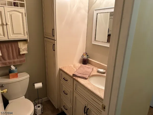 a bathroom with a granite countertop toilet and sink