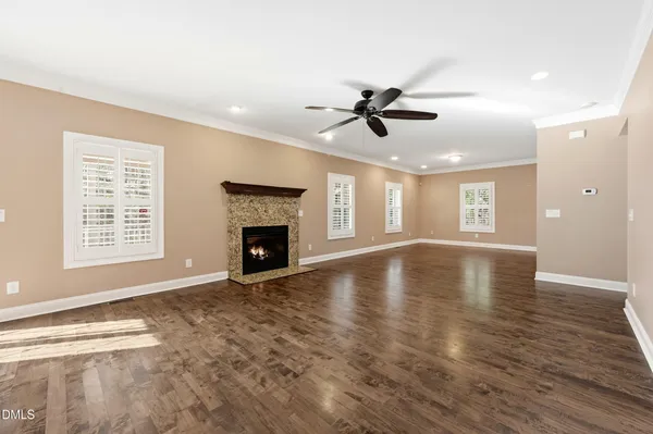 a view of empty room with wooden floor and fireplace