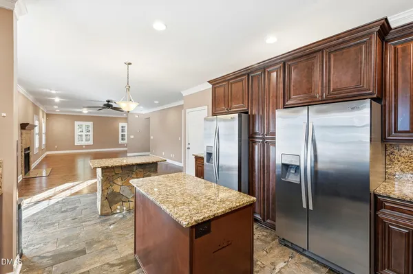 a kitchen with a stove a sink dishwasher a kitchen island with wooden cabinets and floor